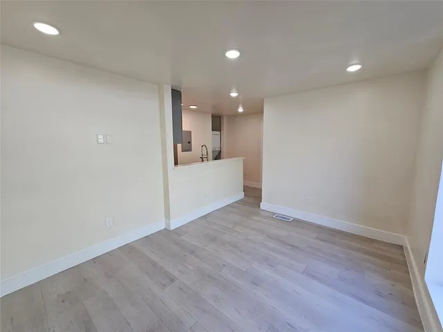 a view of a kitchen with a sink and wooden floor