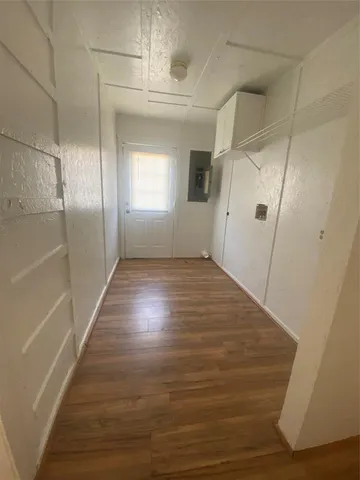 a view of an empty room with wooden floor and staircase