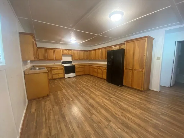 a kitchen with a wooden floor and a refrigerator