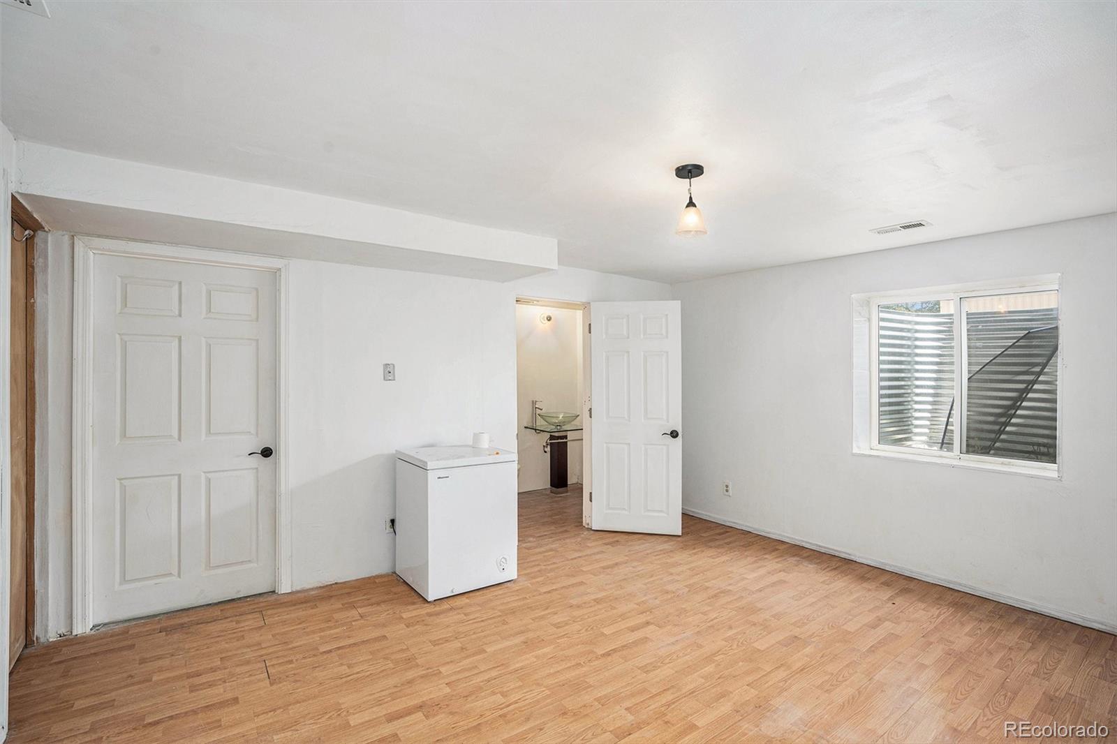 13485 Woodlake Road Elbert, CO 80106 - Photo 15 of 25 a view of an empty room with wooden floor and a window