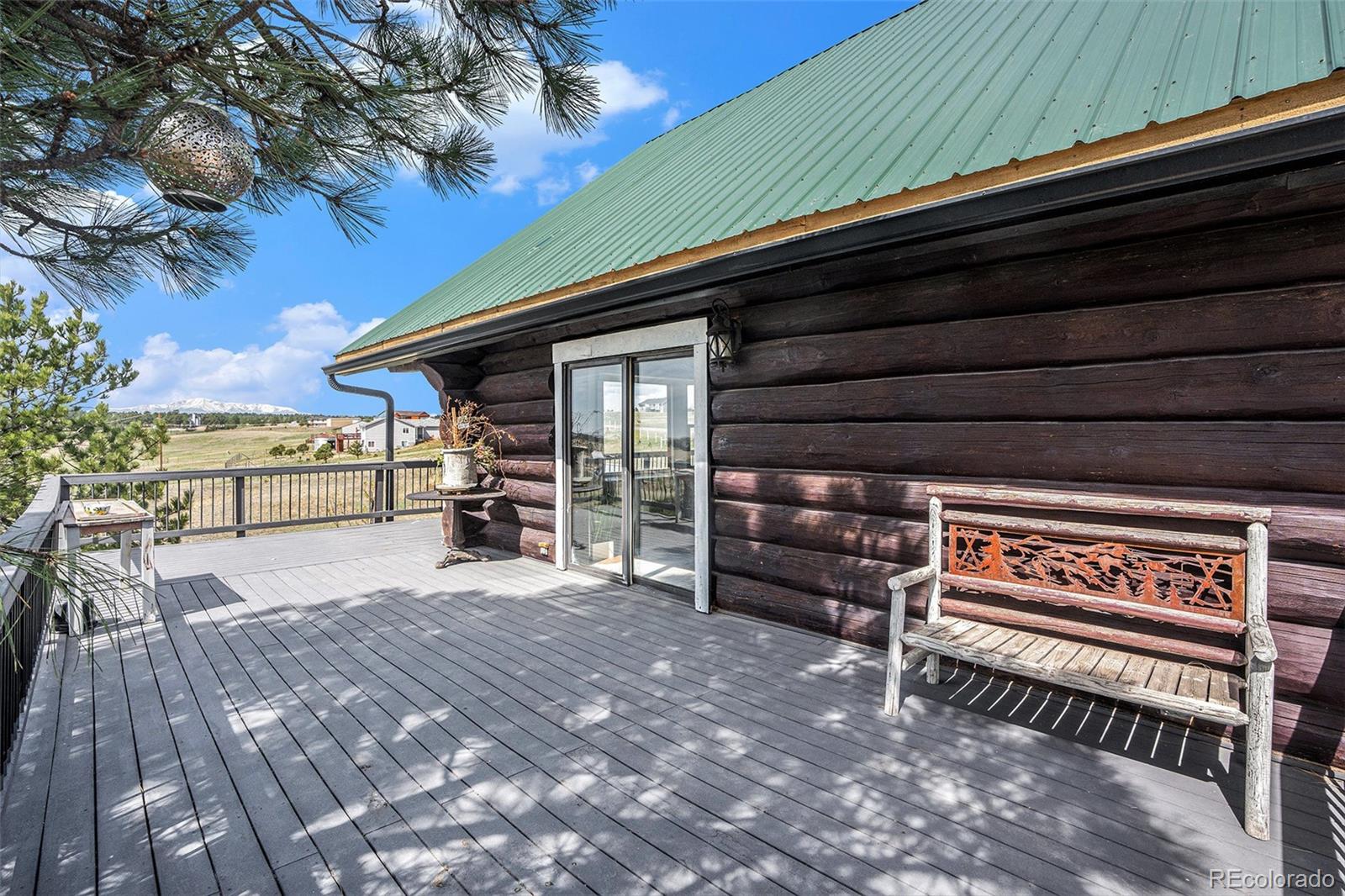 13485 Woodlake Road Elbert, CO 80106 - Photo 19 of 25 a view of a patio with table and chairs with wooden floor and fence