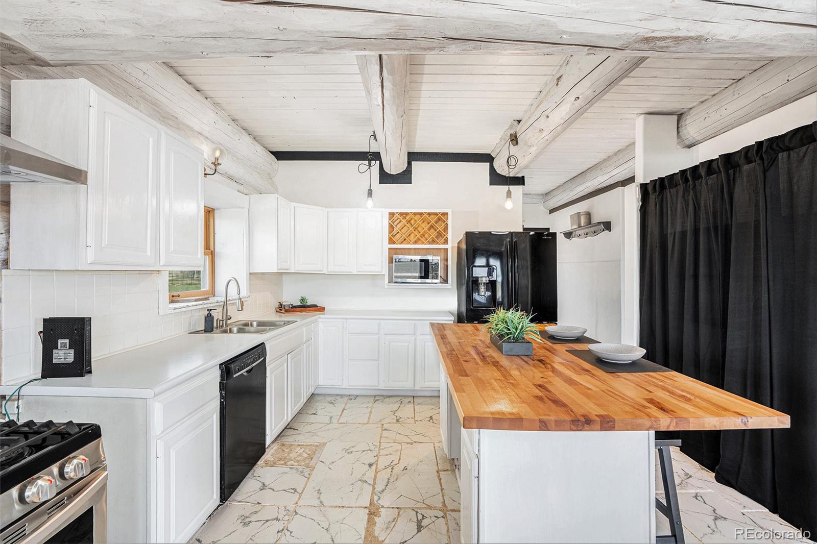 13485 Woodlake Road Elbert, CO 80106 - Photo 3 of 25 a large kitchen with stainless steel appliances granite countertop a sink and cabinets