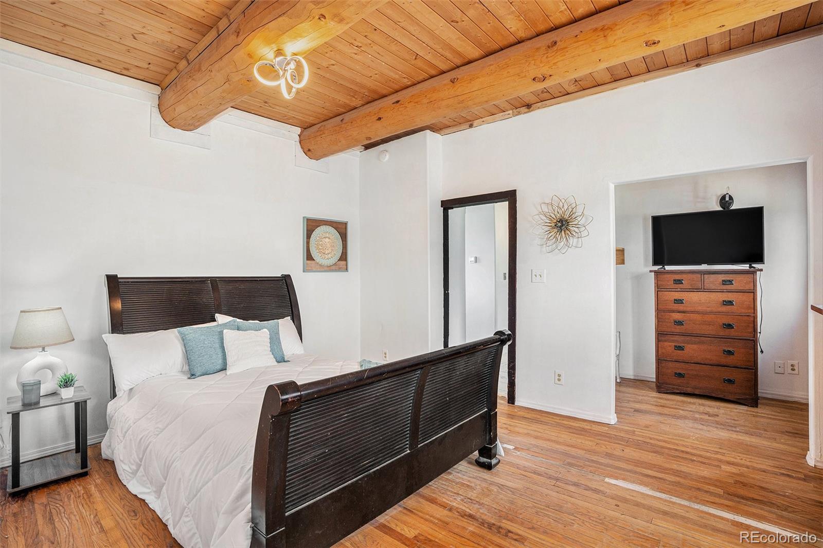 13485 Woodlake Road Elbert, CO 80106 - Photo 9 of 25 a bedroom with a bed and a flat tv screen