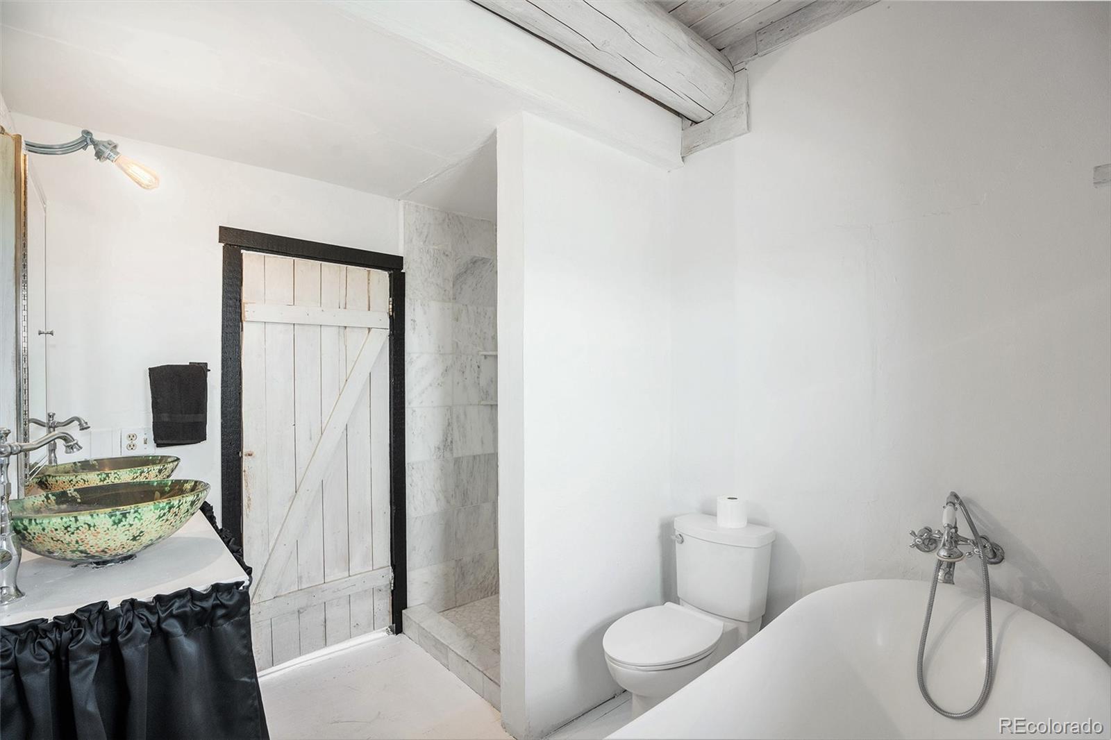 13485 Woodlake Road Elbert, CO 80106 - Photo 10 of 25 a bathroom with a sink toilet and shower