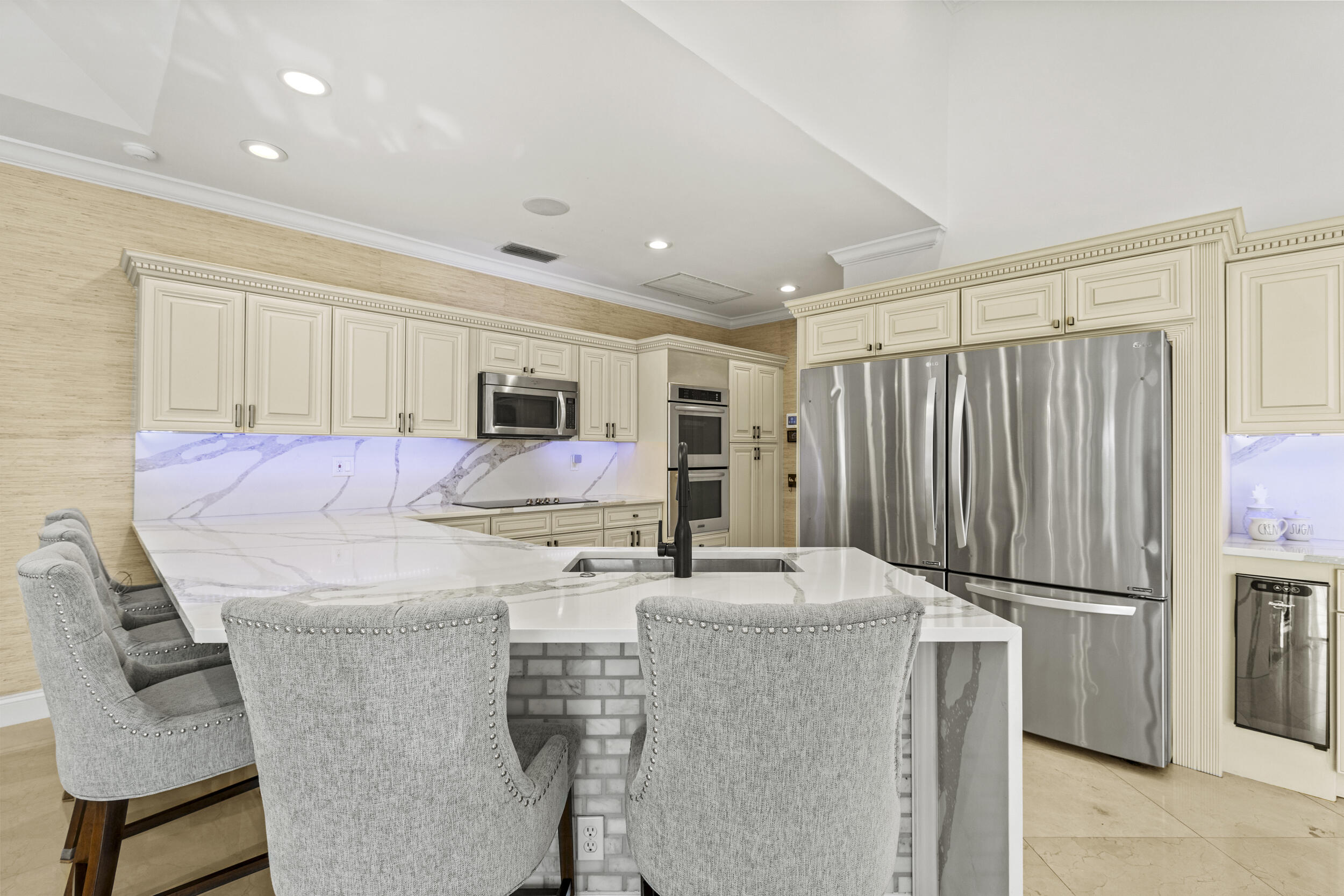 10431 Stonebridge Boulevard Boca Raton, FL 33498 - Photo 15 of 52 a kitchen with stainless steel appliances kitchen island granite countertop a refrigerator and a stove top oven