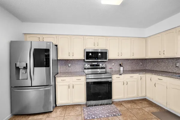 a kitchen with cabinets stainless steel appliances and sink