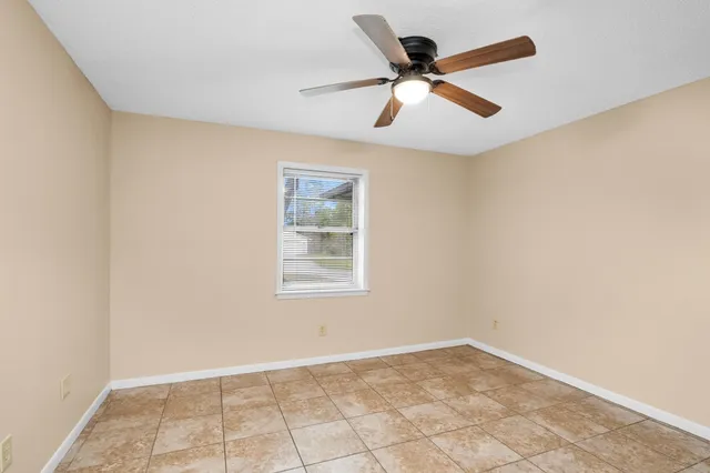 an empty room with a window and a ceiling fan