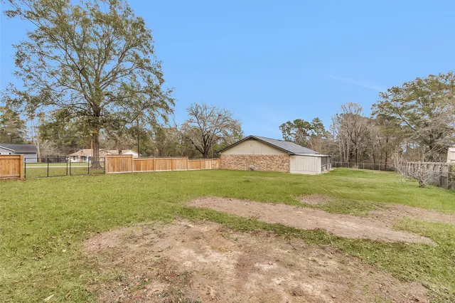 a view of a house with a big yard and large trees