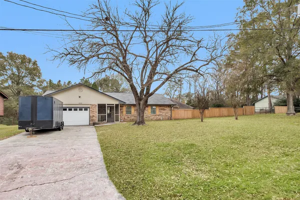 a view of house with yard and trees in the background