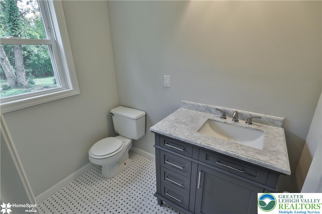 919 Point Phillips Road Bath, PA 18014 - Photo 18 of 59 A well-appointed bath features a sleek vanity with a marble countertop, set against fresh walls and crisp tile flooring.