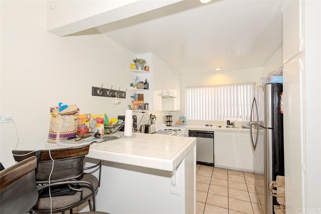 239 Avenida Santa Barbara San Clemente, CA 92672 - Photo 24 of 29 a kitchen with a sink a stove a refrigerator and white table chairs