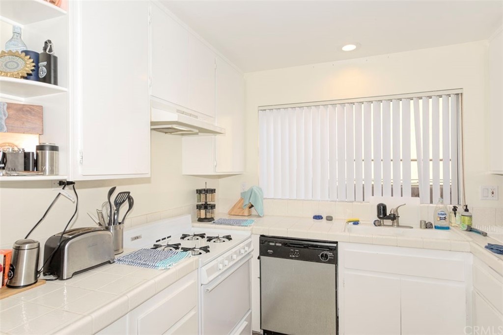 239 Avenida Santa Barbara San Clemente, CA 92672 - Photo 25 of 29 a kitchen with white cabinets sink and white appliances
