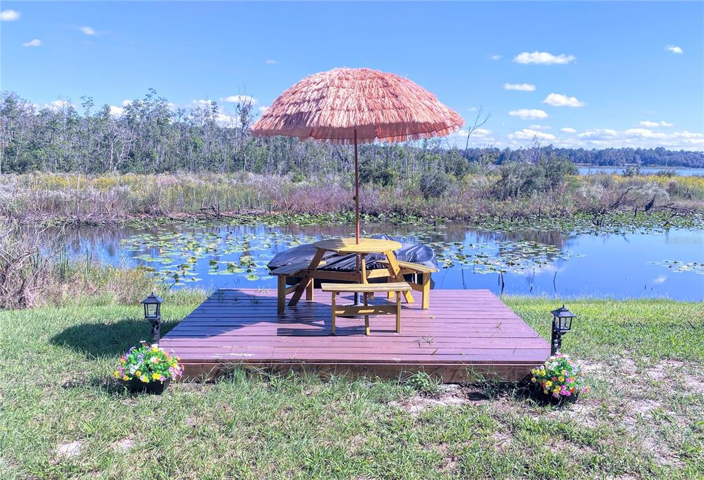 208 Ashley Street Hawthorne, FL 32640 - Photo 30 of 32 an outdoor sitting area with furniture and umbrella