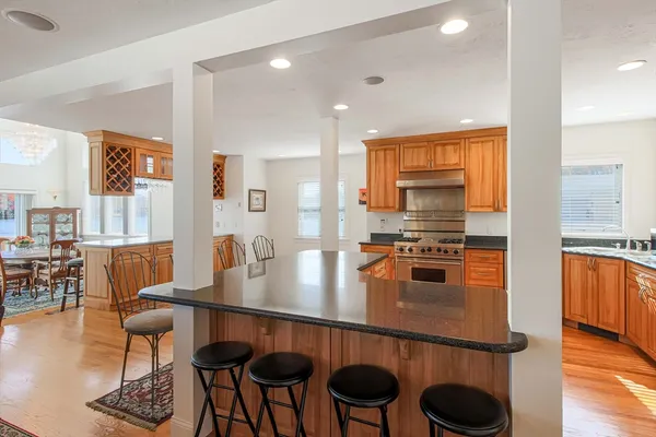 a kitchen with stainless steel appliances granite countertop counter space and chairs in it