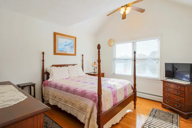 a bedroom with a bed and a flat tv screen on dresser