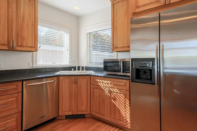 a kitchen with stainless steel appliances granite countertop a refrigerator and a sink