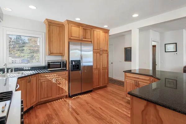 a kitchen with stainless steel appliances granite countertop a refrigerator and a stove top oven