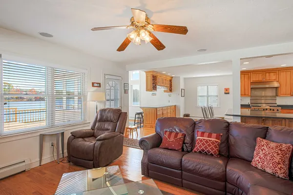 a living room with furniture ceiling fan and a window