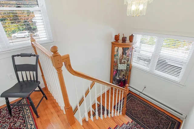 a view of a hallway with wooden floor and stairs