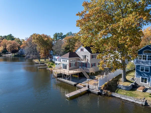 an aerial view of residential houses with outdoor space and lake view