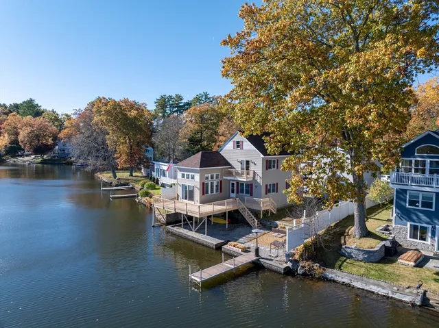 an aerial view of residential houses with outdoor space and lake view