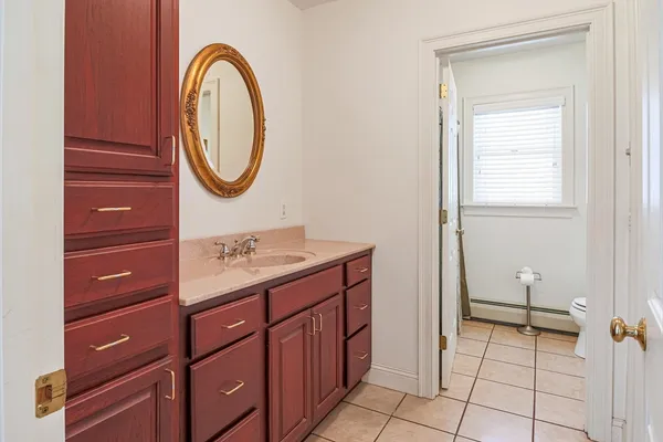 a bathroom with a sink a toilet and a mirror
