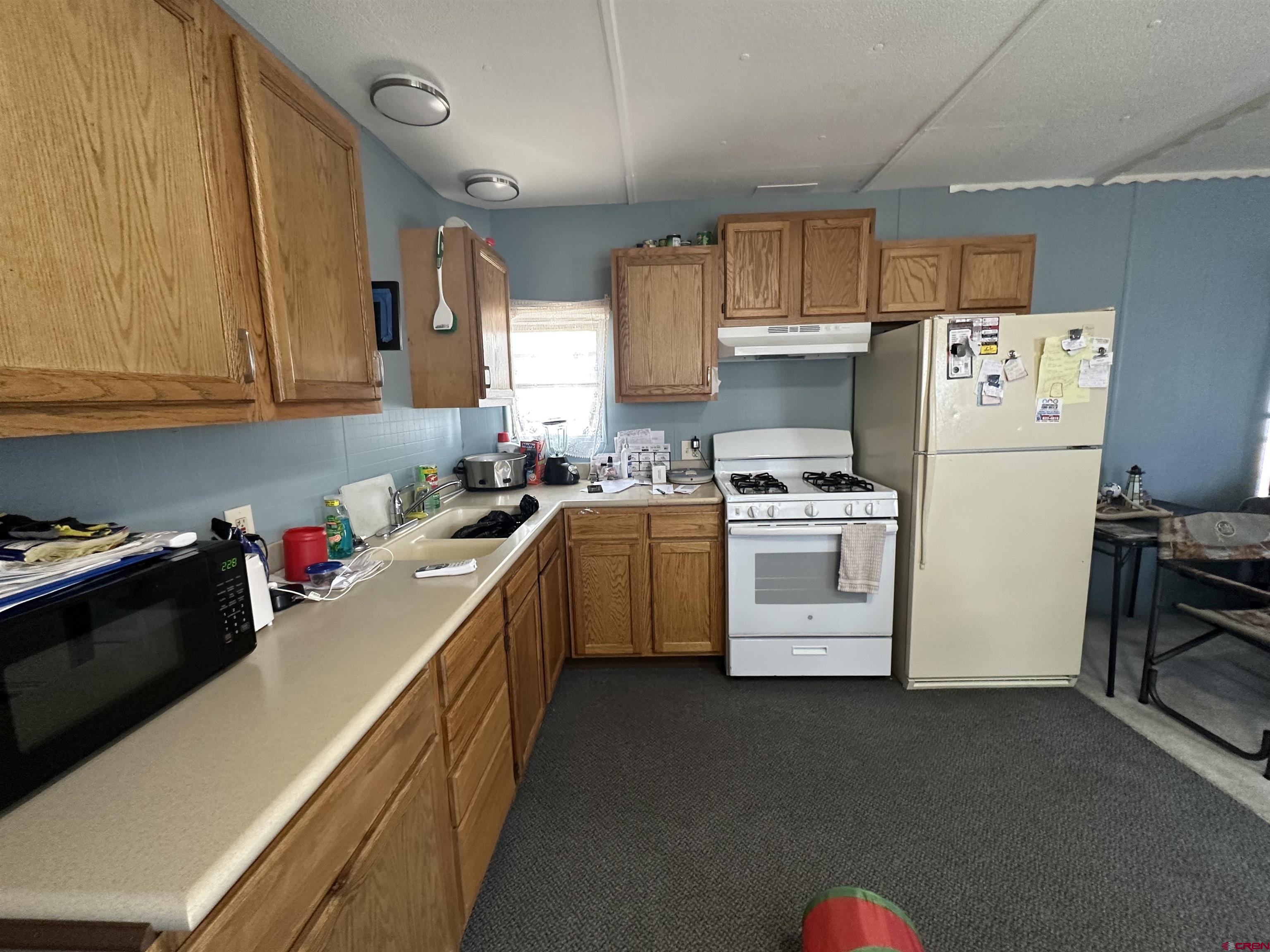 609 South Beech Street Cortez, CO 81321 - Photo 5 of 8 a kitchen with a white cabinets and white appliances