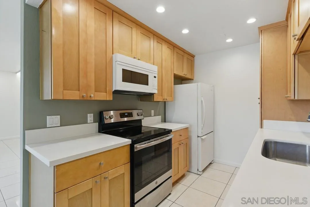 8536 Via Mallorca, Unit B La Jolla, CA 92037 - Photo 4 of 34 a kitchen with stainless steel appliances a stove a microwave and a refrigerator