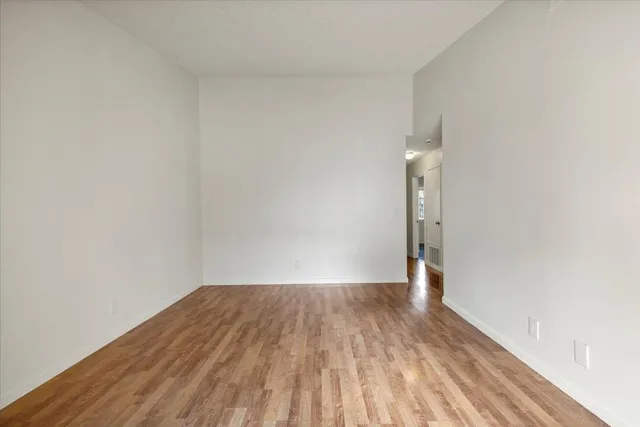 a view of a room with wooden floor