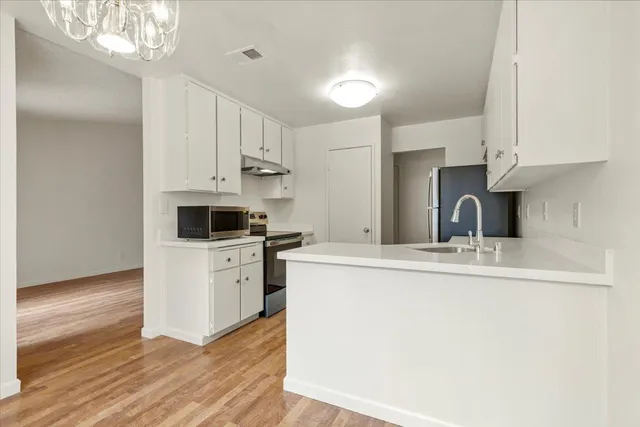 a kitchen with cabinets appliances a sink and a counter space