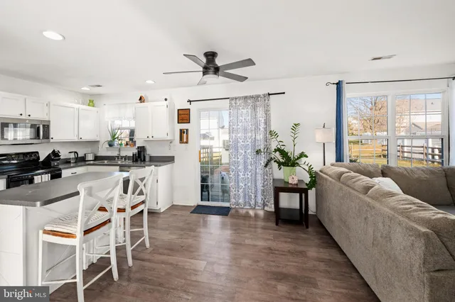 a living room with stainless steel appliances furniture and a large window
