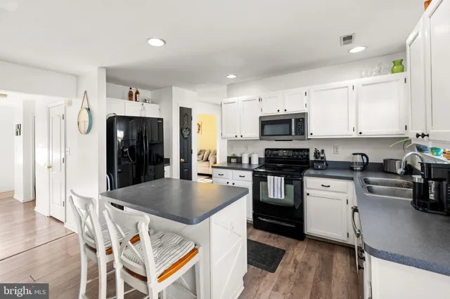 a kitchen with granite countertop a refrigerator stove top oven and sink