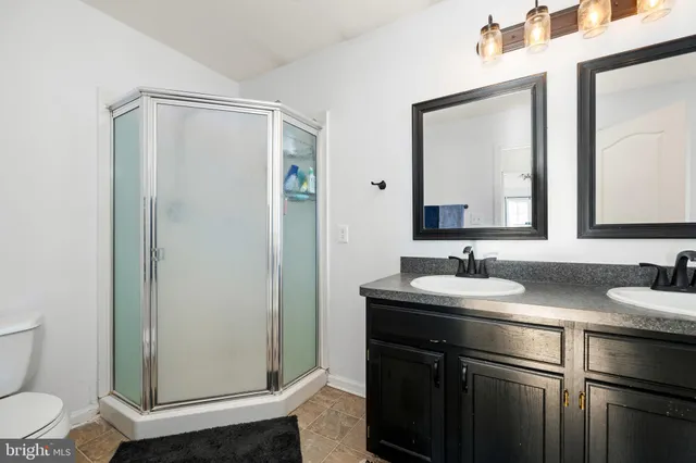 a bathroom with a double vanity sink mirror and toilet
