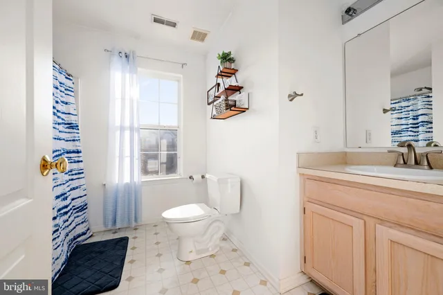 a bathroom with a sink a toilet and a window
