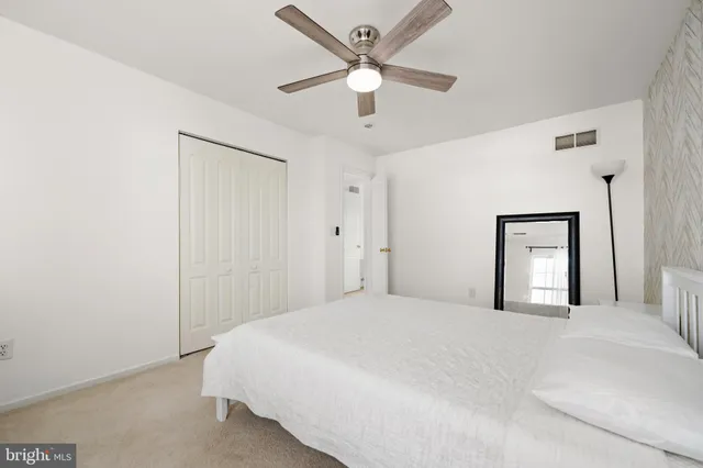 a bedroom with a bed and a ceiling fan