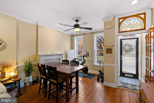 a dining room with furniture a chandelier and wooden floor