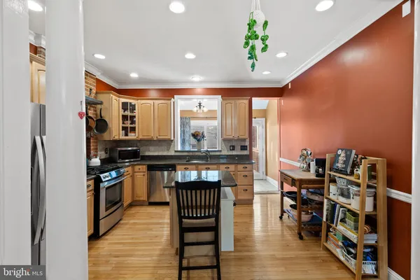 a kitchen with granite countertop stainless steel appliances a sink a counter top space and cabinets
