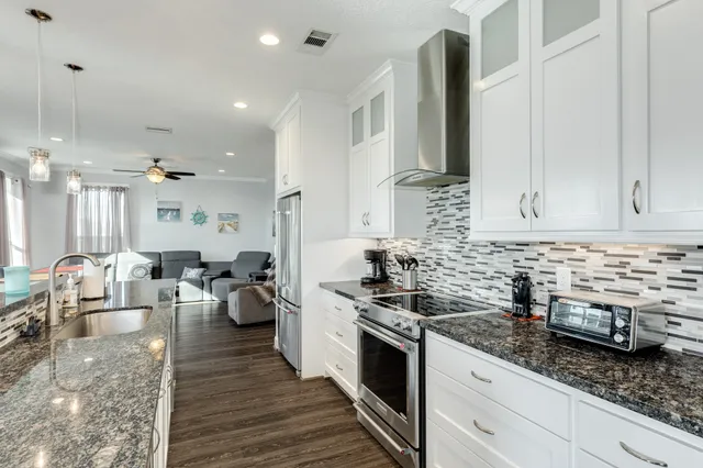 a large kitchen with kitchen island a sink stove and wooden floor