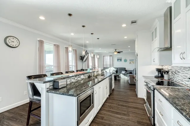 a kitchen with stainless steel appliances granite countertop a refrigerator a sink and a stove
