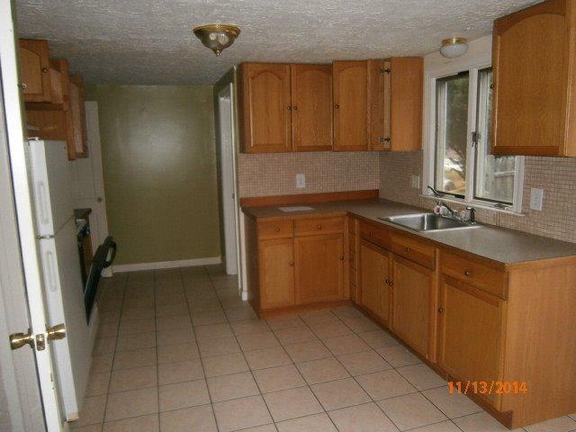 149 Seabrook Road, Unit 1 & 2 Hyannis, MA 02601 - Photo 13 of 16 a kitchen with a sink refrigerator and cabinets