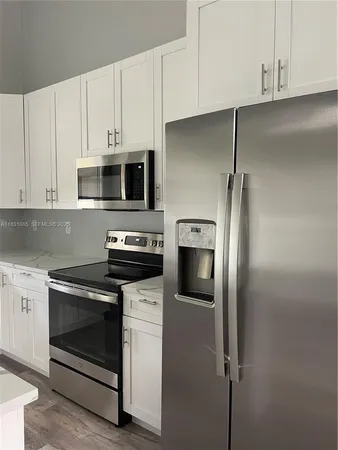 a kitchen with cabinets stainless steel appliances and a counter space