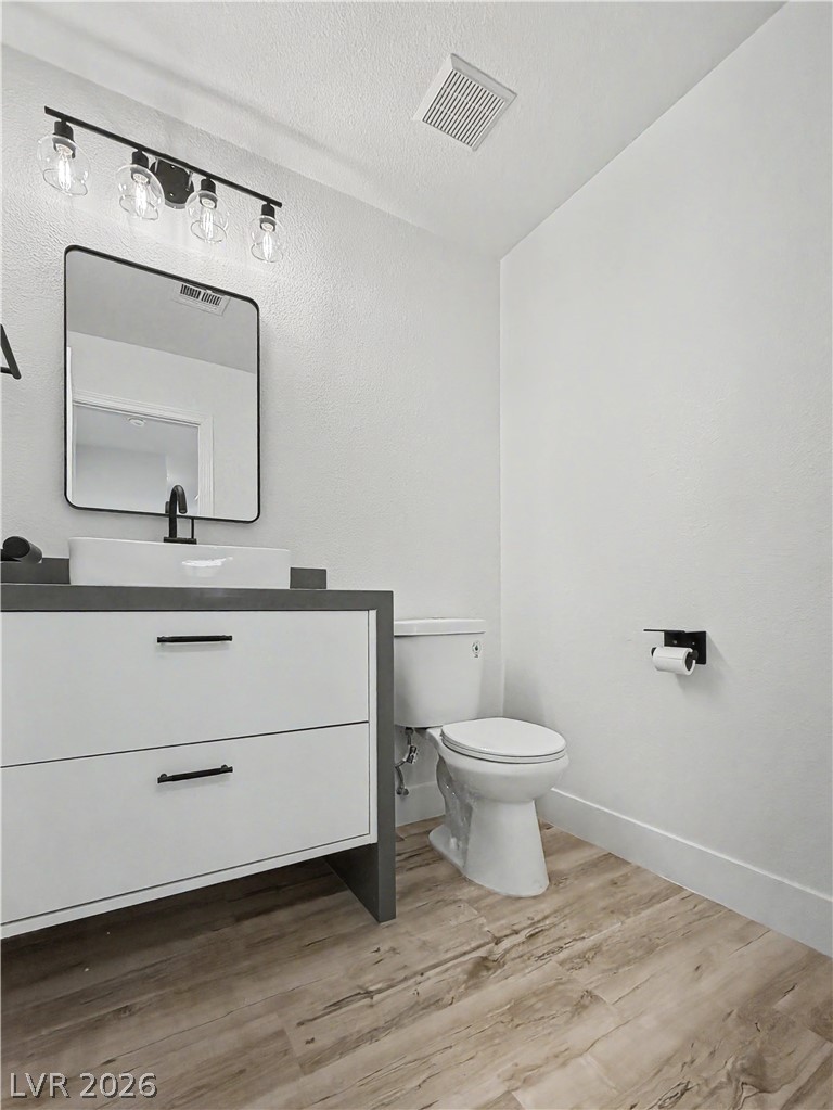 8977 Paige Rene Court Las Vegas, NV 89117 - Photo 22 of 31 A well-lit powder room showcases a modern vanity and wood-look flooring.