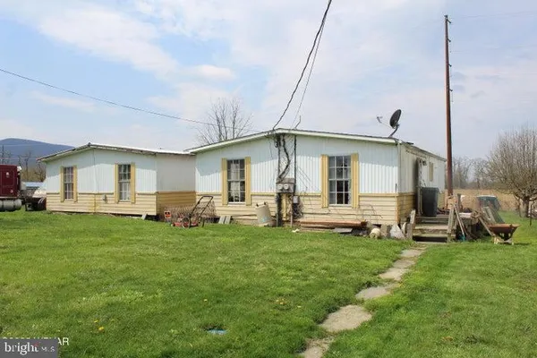 a view of a house with a backyard and chairs