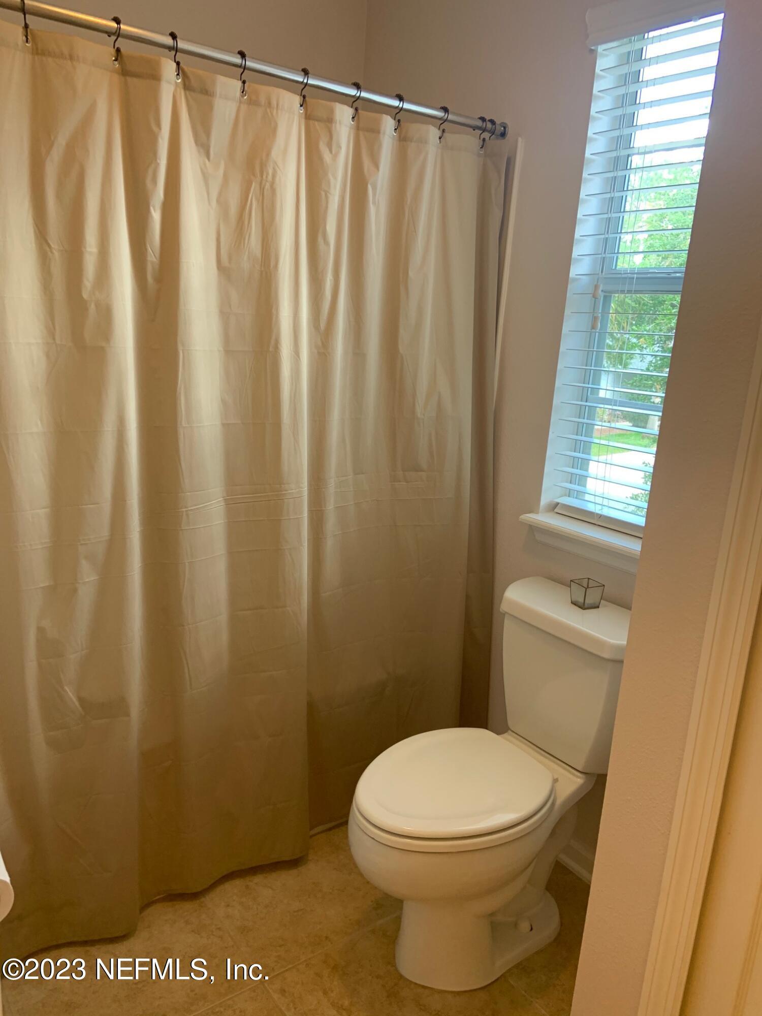 3863 Chasing Falls Road Orange Park, FL 32065 - Photo 19 of 32 a white toilet sitting next to a shower curtain