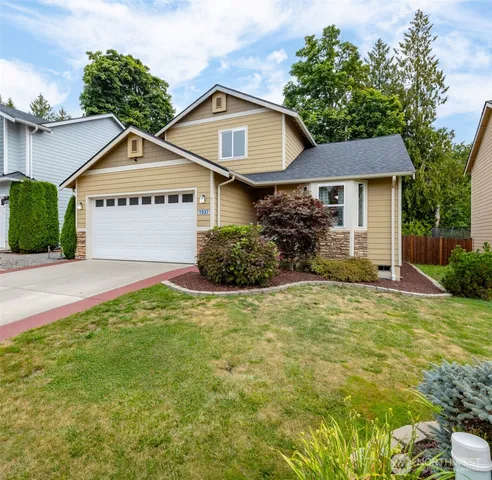 a front view of a house with a yard and garage