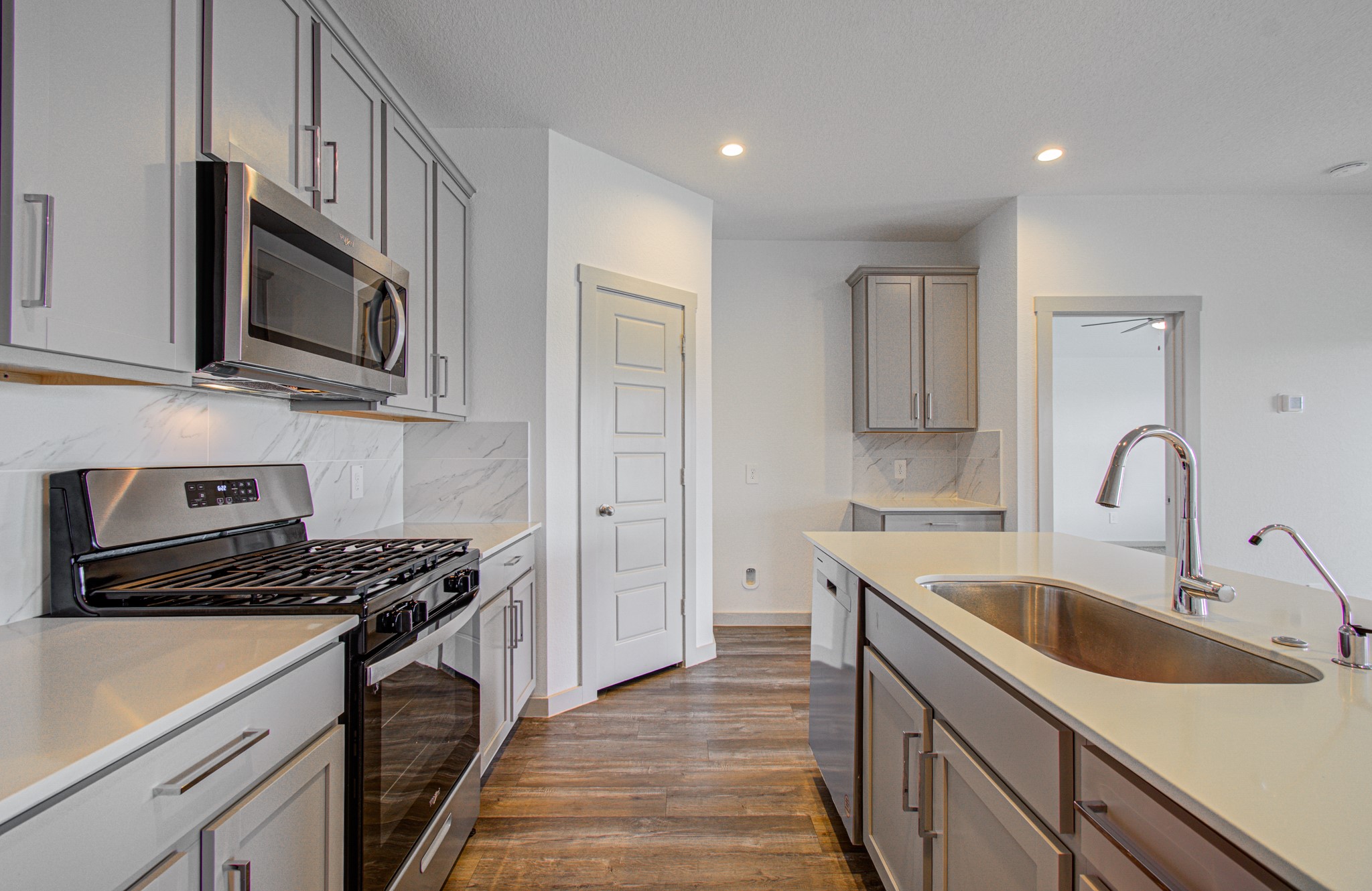 7903 Wrangler Shack Lane Rosharon, TX 77583 - Photo 17 of 36 Modern kitchen featuring sleek stainless steel appliances, elegant cabinetry, and a spacious island with a built-in sink.