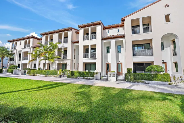 a front view of a building with a garden and plants