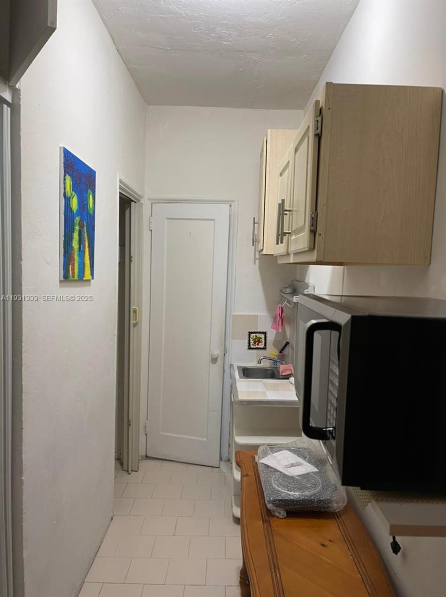6830 Harding Avenue, Unit 2 Miami Beach, FL 33141 - Photo 6 of 6 a kitchen with stainless steel appliances granite countertop a refrigerator and a stove