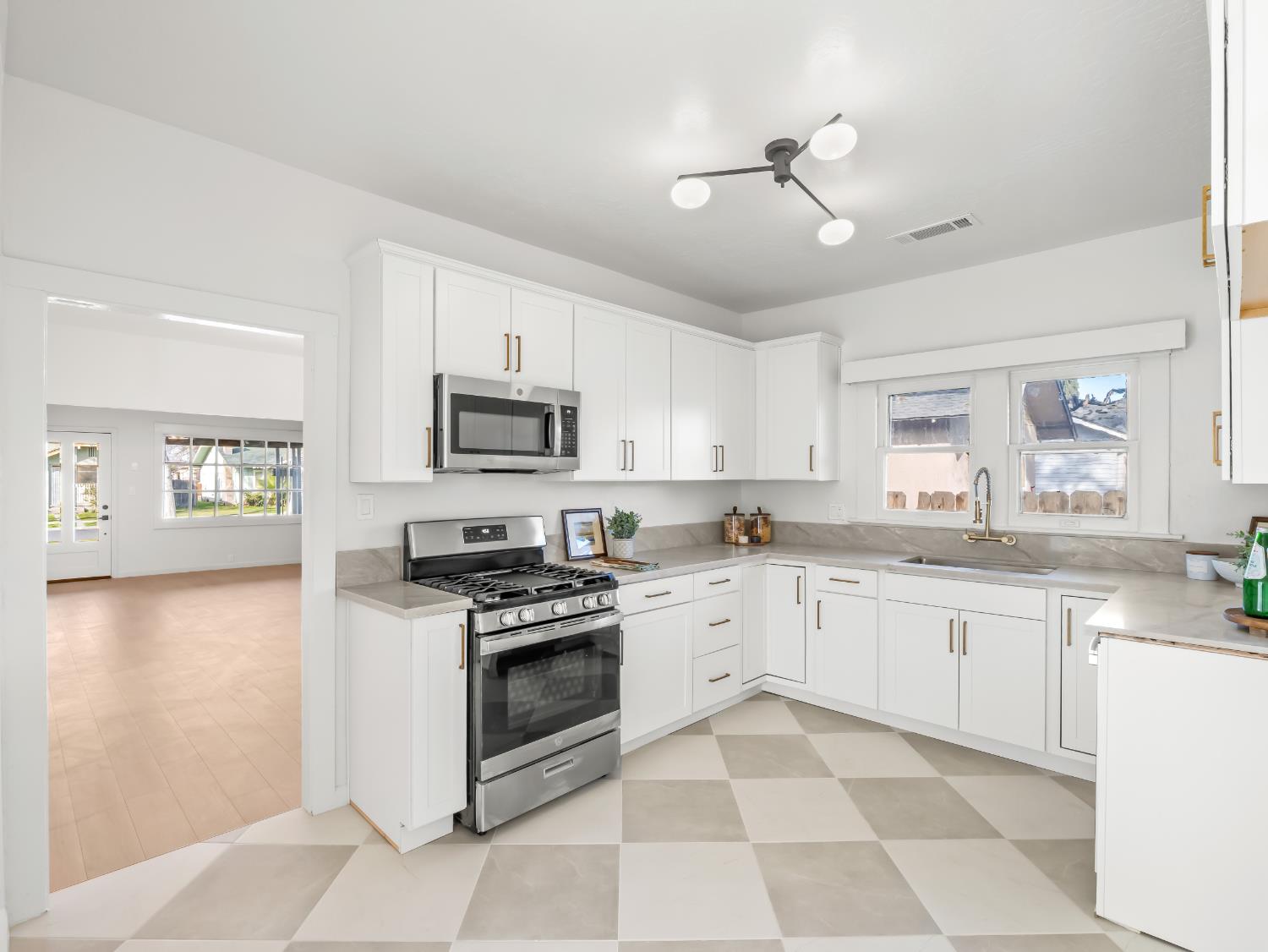 425 West Elm Street Hanford, CA 93230 - Photo 6 of 18 a kitchen with granite countertop appliances cabinets a sink and a counter top space