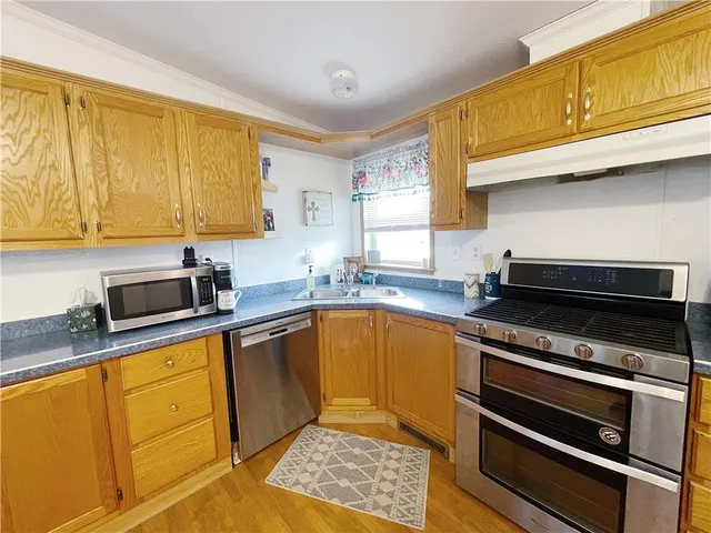 a kitchen with stainless steel appliances granite countertop a sink stove and cabinets